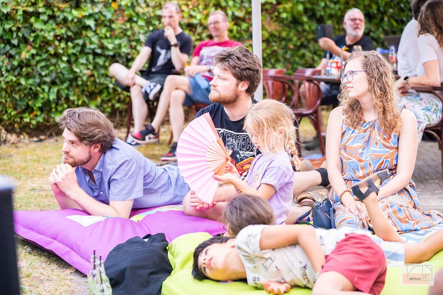 Bezoekers liggen en zitten in het gras te luisteren naar de muziek — foto: GEKfoto
