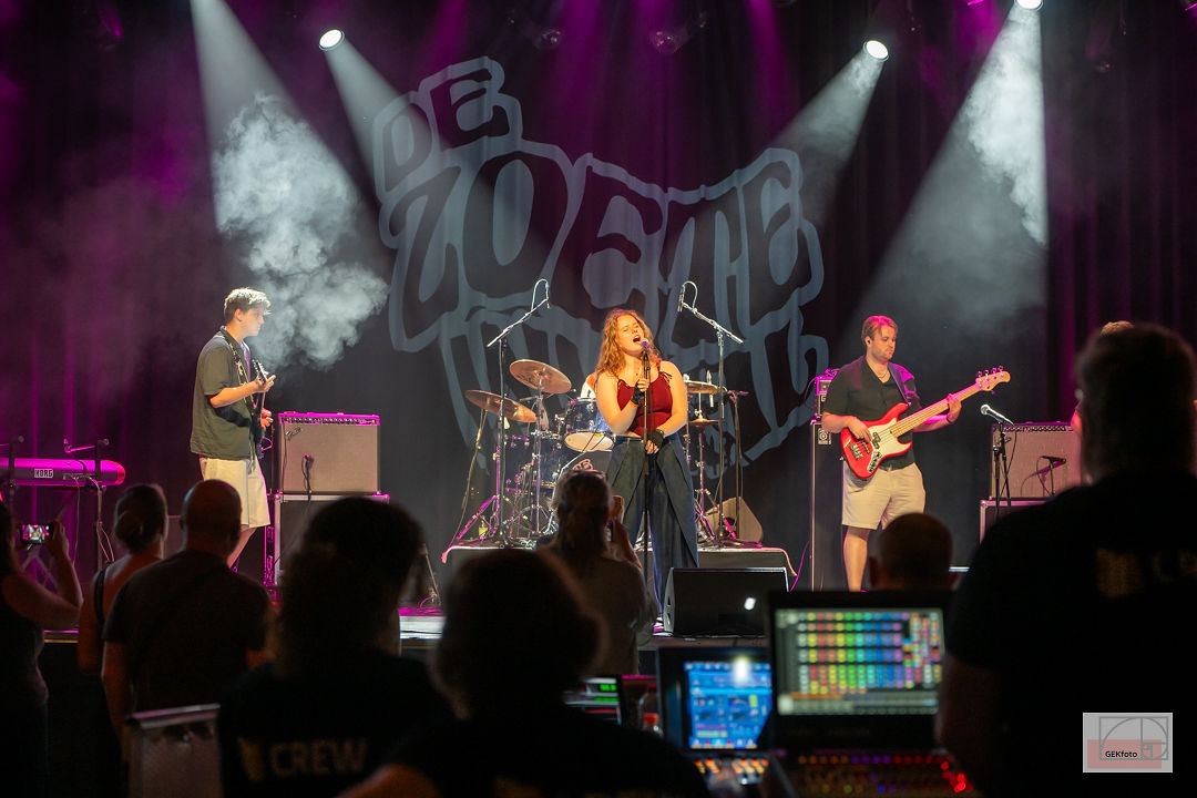 Zangeres en band voor het De Zoete Inval-doek in rook en wit spotlicht — foto: GEKfoto